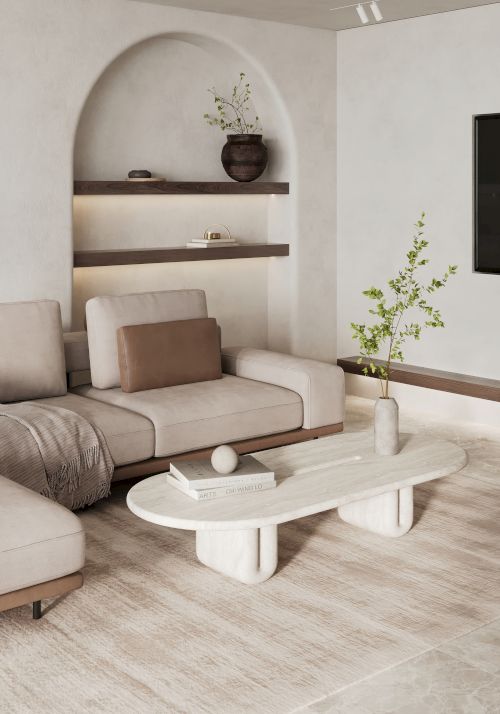 A modern, minimalist living room with a beige sectional sofa, a sleek white coffee table, shelving with decor, and a plant in the corner.